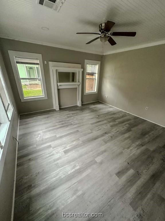 unfurnished bedroom with hardwood / wood-style flooring, ceiling fan, and ornamental molding