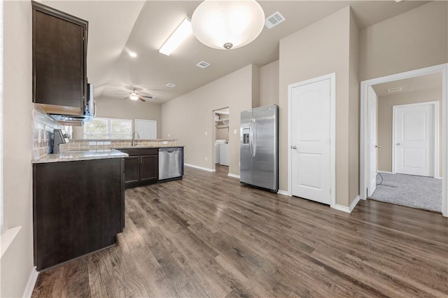 109 Dove Ct, Navasota, TX 77868 - kitchen with appliances with stainless steel finishes, dark brown cabinets, washer / clothes dryer, a sink, and lofted ceiling