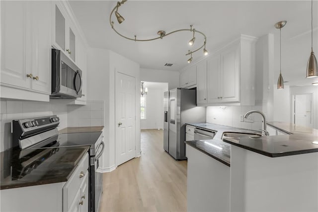 kitchen featuring sink, hanging light fixtures, kitchen peninsula, white cabinets, and appliances with stainless steel finishes