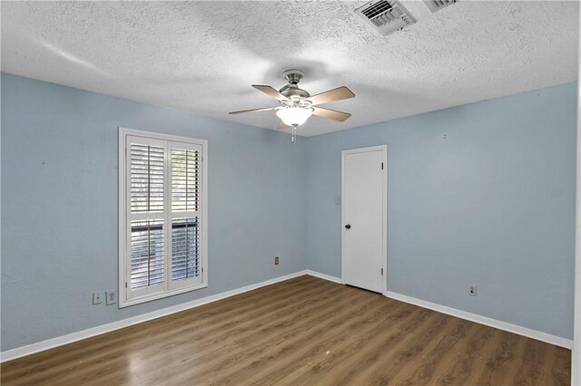 spare room with dark hardwood / wood-style floors, ceiling fan, and a textured ceiling