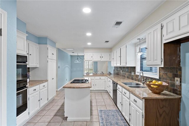 kitchen with a center island, sink, decorative backsplash, light tile patterned floors, and white cabinetry