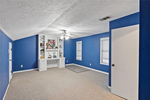 unfurnished bedroom with vaulted ceiling, ceiling fan, light carpet, and a textured ceiling