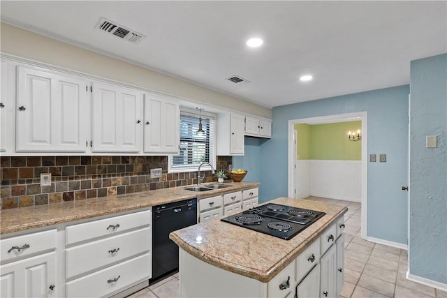 kitchen featuring a center island, sink, light stone counters, white cabinets, and black appliances