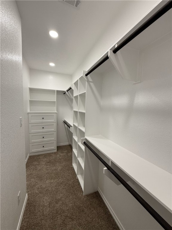 walk in closet featuring dark colored carpet