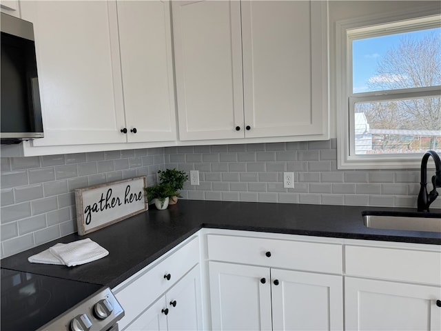 kitchen featuring tasteful backsplash, stainless steel appliances, sink, and white cabinets