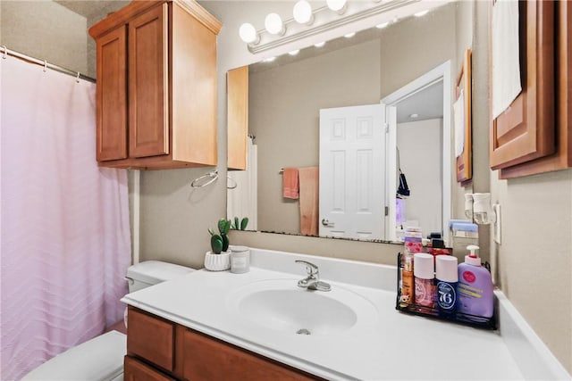 bathroom with toilet, curtained shower, and vanity