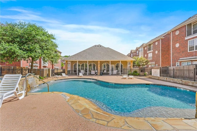 community pool featuring a patio area and fence