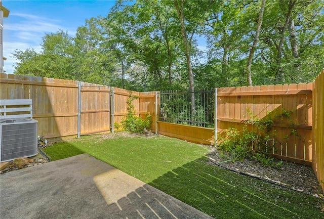 view of yard featuring a fenced backyard, central AC unit, and a patio area