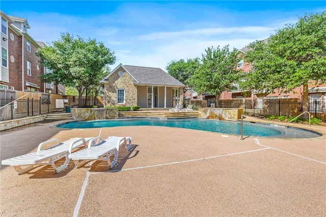 pool with an outbuilding, fence, a patio, and a storage structure