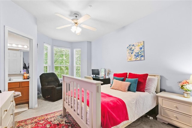 bedroom featuring a ceiling fan, connected bathroom, and light colored carpet