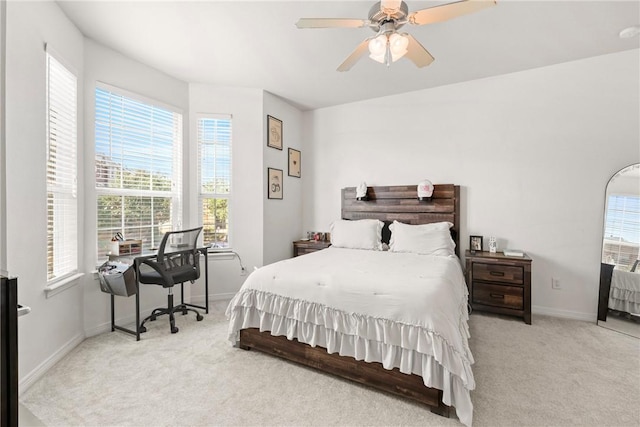 carpeted bedroom with baseboards, multiple windows, and a ceiling fan