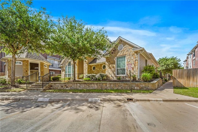 view of front of house with fence and stone siding