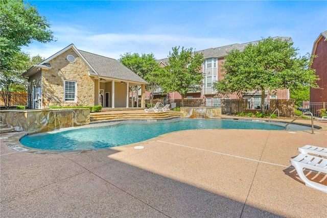pool featuring a patio, an exterior structure, fence, and an outdoor structure