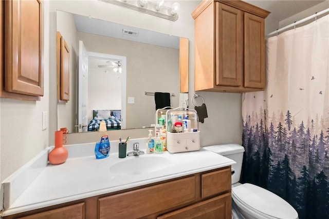 bathroom with visible vents, a shower with curtain, toilet, a ceiling fan, and vanity