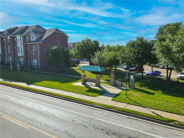 view of home's community featuring a yard and fence