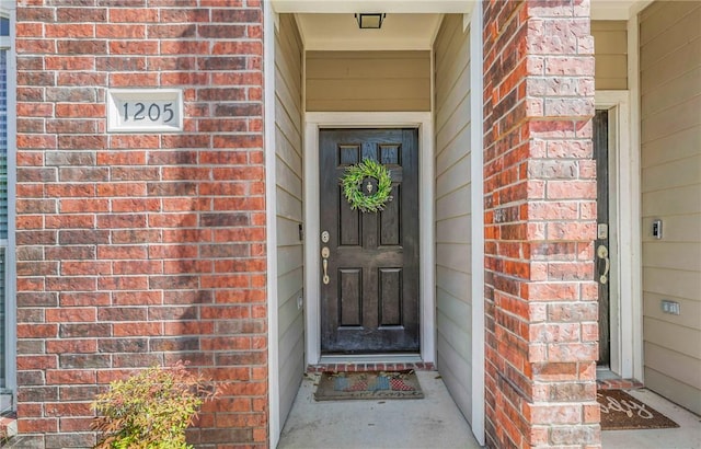 view of exterior entry with brick siding