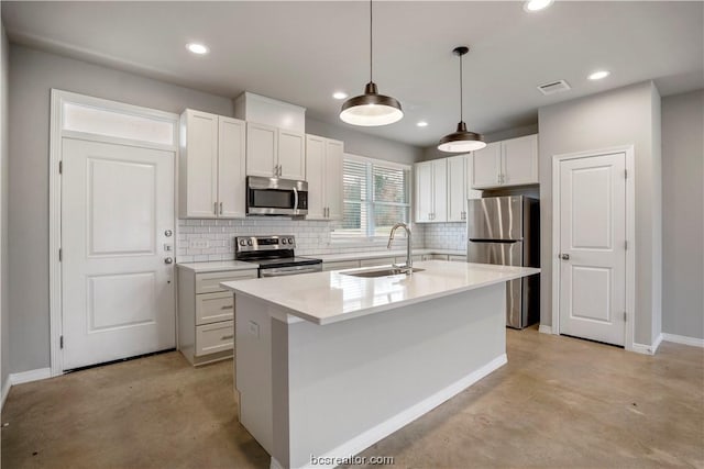 kitchen with stainless steel appliances, sink, pendant lighting, a center island with sink, and white cabinetry