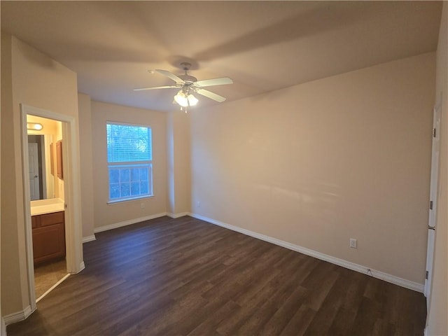 unfurnished bedroom featuring ceiling fan, dark wood-type flooring, and connected bathroom