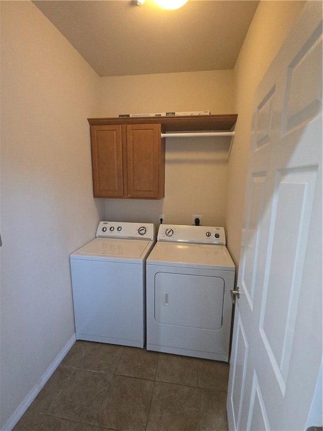 washroom with cabinets, separate washer and dryer, and dark tile patterned flooring