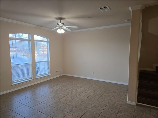 spare room with ceiling fan, ornamental molding, and light tile patterned floors