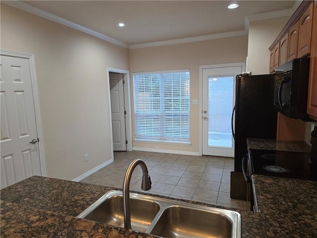 kitchen with light tile patterned floors, crown molding, and sink