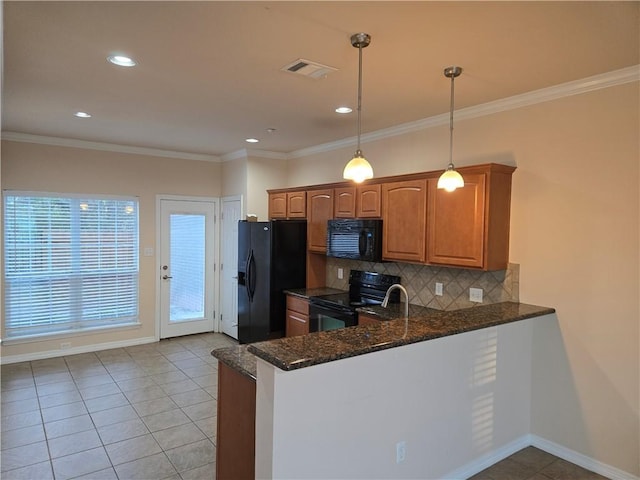 kitchen featuring black appliances, decorative light fixtures, dark stone countertops, and crown molding