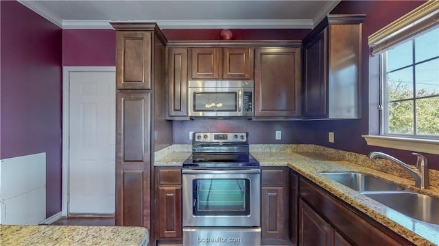 2487 Horse Shoe Dr, College Station, TX 77845 - kitchen with appliances with stainless steel finishes, a sink, ornamental molding, and light stone counters