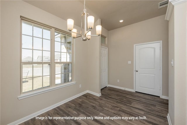 unfurnished dining area with dark hardwood / wood-style flooring and an inviting chandelier