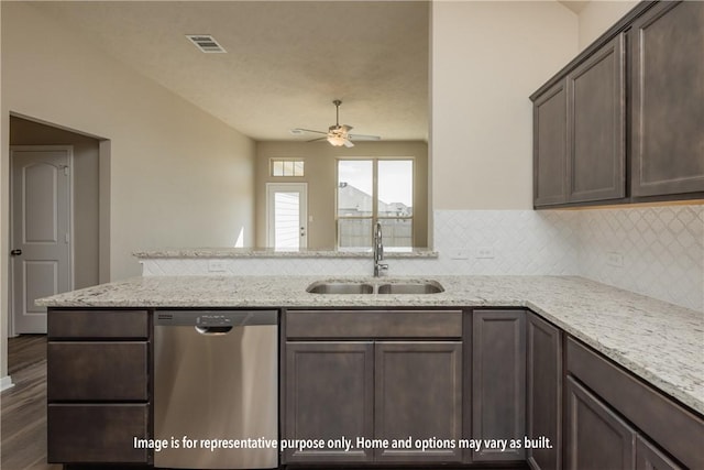 kitchen with light stone countertops, stainless steel dishwasher, dark brown cabinetry, ceiling fan, and sink