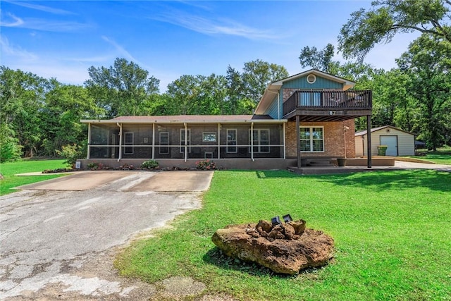 87 Tonkawa Dr, Normangee, TX 77871 - back of house with a sunroom, an outdoor structure, a lawn, a garage, and asphalt driveway