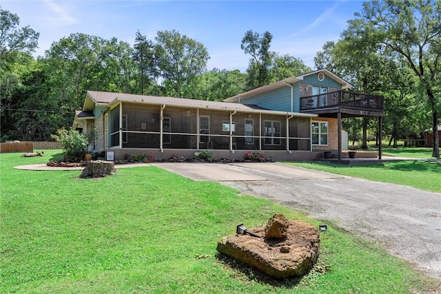 87 Tonkawa Dr, Normangee, TX 77871 - rear view of house featuring a sunroom and a lawn