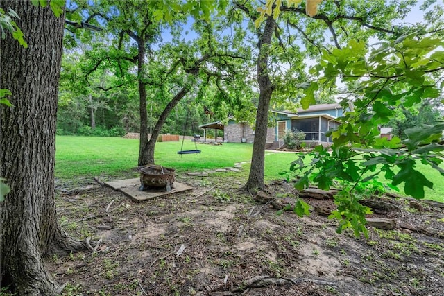 87 Tonkawa Dr, Normangee, TX 77871 - view of green lawn featuring an outdoor fire pit and a sunroom