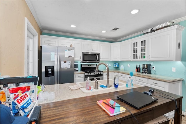 87 Tonkawa Dr, Normangee, TX 77871 - kitchen featuring appliances with stainless steel finishes, white cabinetry, glass insert cabinets, light stone countertops, and recessed lighting