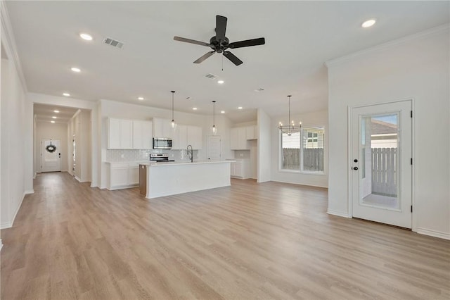 unfurnished living room featuring ceiling fan with notable chandelier, crown molding, sink, and light hardwood / wood-style flooring