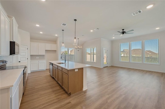 kitchen featuring appliances with stainless steel finishes, tasteful backsplash, a spacious island, sink, and white cabinetry