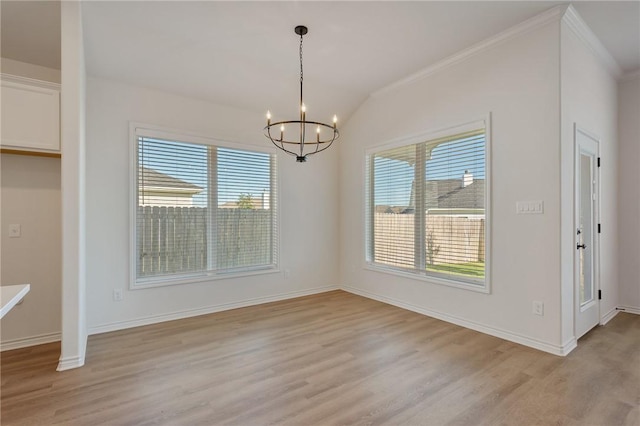 unfurnished dining area with light hardwood / wood-style flooring, ornamental molding, vaulted ceiling, and an inviting chandelier