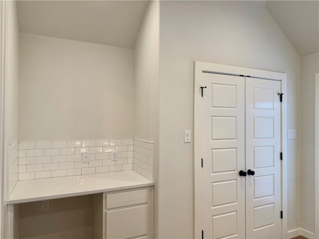 bathroom featuring decorative backsplash and lofted ceiling