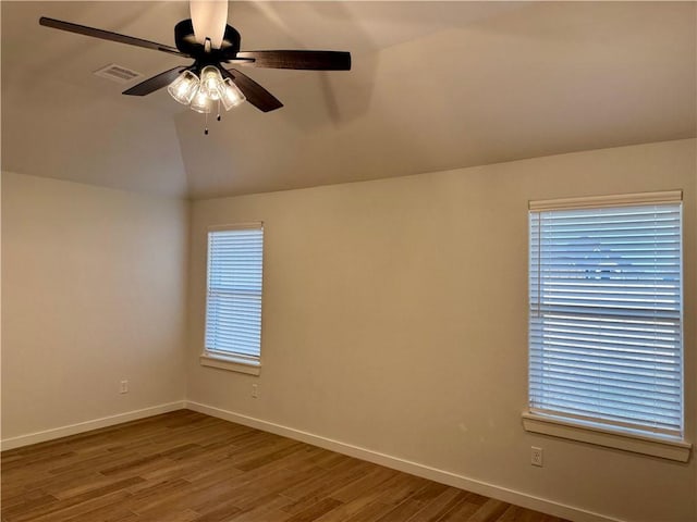 empty room with hardwood / wood-style flooring, ceiling fan, and lofted ceiling