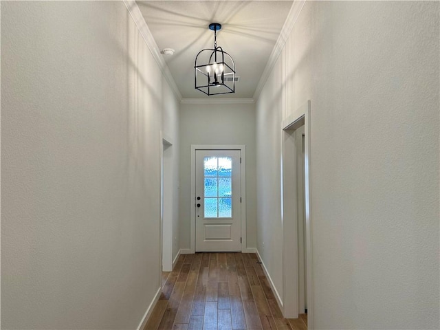 doorway to outside featuring a chandelier, hardwood / wood-style floors, and ornamental molding