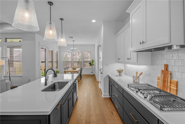 3576 Chantilly Path, Bryan, TX 77808 - kitchen featuring stainless steel appliances, white cabinetry, light countertops, a chandelier, and light wood-type flooring