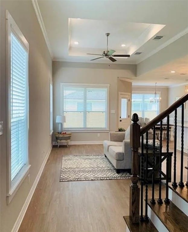 2130 Mountain Wind Loop, Bryan, TX 77807 - living room featuring healthy amount of natural light, a raised ceiling, wood finished floors, a chandelier, and ornamental molding