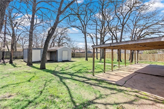 view of yard with a storage shed, a fenced backyard, and an outbuilding