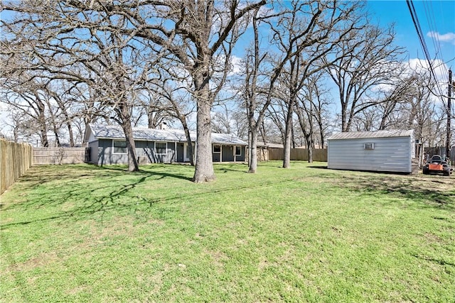 view of yard featuring a storage unit, an outdoor structure, and a fenced backyard