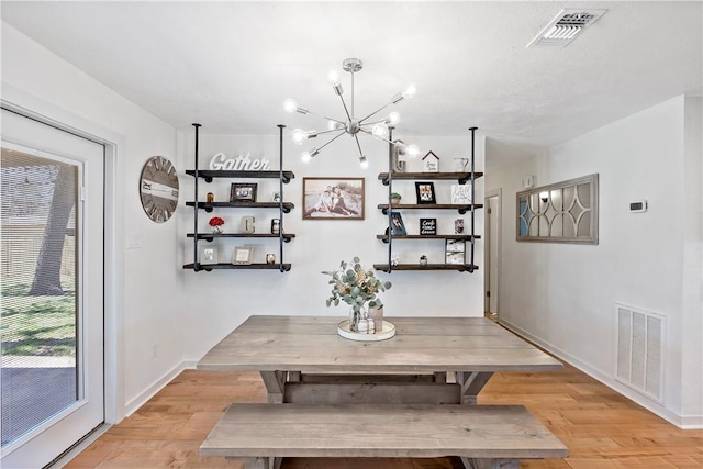 dining area featuring a chandelier, baseboards, visible vents, and light wood finished floors