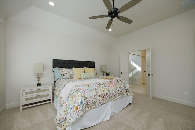 bedroom with ceiling fan, light colored carpet, ensuite bathroom, and lofted ceiling