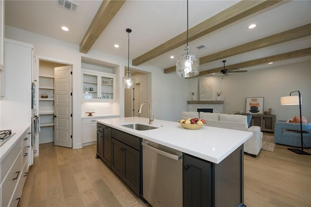 kitchen with beam ceiling, white cabinetry, sink, stainless steel appliances, and a fireplace