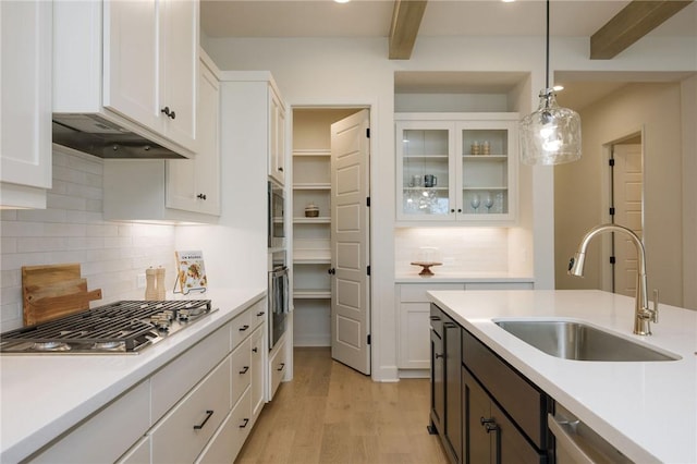 kitchen with beam ceiling, white cabinetry, decorative light fixtures, and appliances with stainless steel finishes