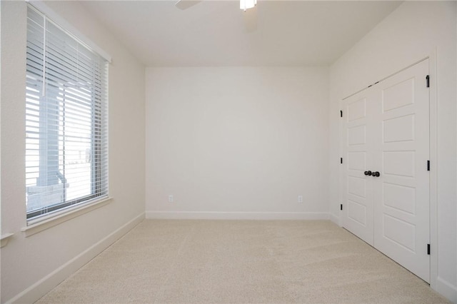 carpeted empty room featuring ceiling fan