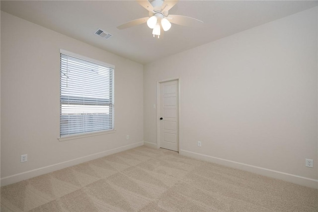 carpeted spare room with ceiling fan