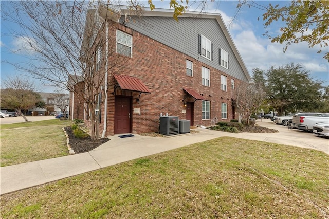 view of property exterior featuring central AC and a yard